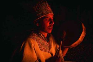 Healer drumming around the sacred fire during a Wachuma ceremony at Templo del Tigre in the Osa Peninsula, Costa Rica.