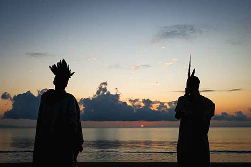 Beach sunrise scene with two healers, capturing the start of a transformative retreat.