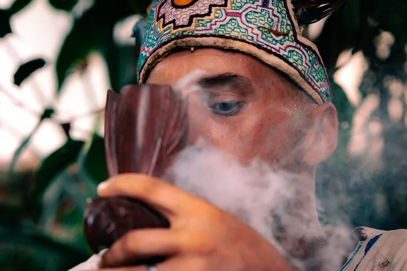 Curandero at Templo del Tigre blowing sacred tobacco smoke in a traditional Mapacho blessing.