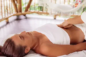 Traditional Maya abdominal massage session at Templo del Tigre retreat center, supporting reproductive and digestive health during a women's master plant dieta integration week in Costa Rica.