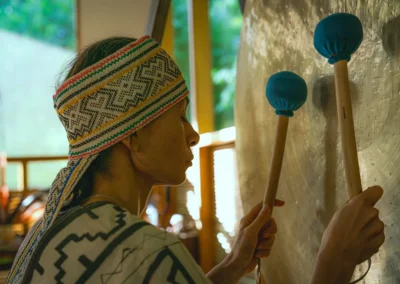 Gong being played during sound healing session at integration week of a plant medicine retreat at Templo del Tigre in Osa Peninsula, Costa Rica.